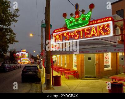 Il neon at Pat's Steaks e Geno's Steaks risplende poco prima dell'alba nel mercato italiano di Philadelphia. Foto Stock