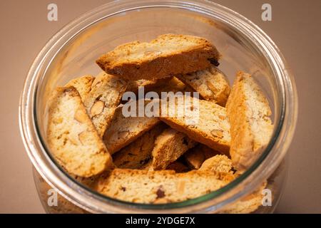 Un vasetto di vetro riempito con cantucci di mandorle italiani, visto dall'alto, i biscotti dorati con mandorle sono impilati all'interno per mostrarne i croccanti Foto Stock