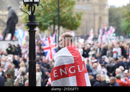 Londra, Regno Unito, 26 ottobre 2024. 1000 di folle di estrema destra che indossavano le bandiere di San Giorgio e gli Union Jacks marciarono verso Whitehall. L'organizzatore Tommy Robinson era assente dalla marcia Unite The Kingdom dopo essere stato rimesso in custodia venerdì. La protesta anti-governativa ha chiesto il rilascio di Robinson e ha insultato il nome di Keir Starmer. Credito : Monica Wells/Alamy Live News Foto Stock