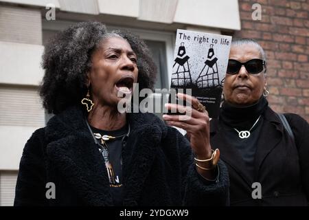 Londra, Regno Unito. 26 ottobre 2024. Marcia Rigg (L), il cui fratello Sean è morto sotto la custodia della polizia nella stazione di polizia di Brixton nel 2008, tiene un opuscolo del 1998 di Keir Starmer intitolato "il diritto alla vita", che documenta la mancanza di garanzie per i diritti umani nel Regno Unito. L'opuscolo, insieme a una lettera, è stato successivamente consegnato al signor Starmer, che ora è primo ministro del Regno Unito, dopo che la United Families and Friends Campaign (UFFC) ha organizzato la loro 25a manifestazione annuale e processione per protestare contro le morti per mano dello Stato e commemorare le vittime perse a causa della violenza statale. Crediti: Ron Fassbender/Alamy Live News Foto Stock