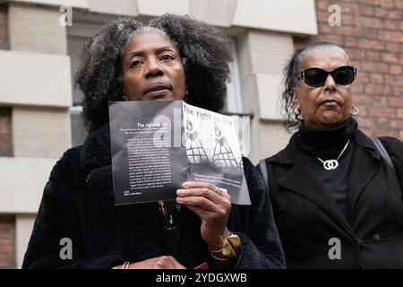 Londra, Regno Unito. 26 ottobre 2024. Marcia Rigg (L), il cui fratello Sean è morto sotto la custodia della polizia nella stazione di polizia di Brixton nel 2008, tiene un opuscolo del 1998 di Keir Starmer intitolato "il diritto alla vita", che documenta la mancanza di garanzie per i diritti umani nel Regno Unito. L'opuscolo, insieme a una lettera, è stato successivamente consegnato al signor Starmer, che ora è primo ministro del Regno Unito, dopo che la United Families and Friends Campaign (UFFC) ha organizzato la loro 25a manifestazione annuale e processione per protestare contro le morti per mano dello Stato e commemorare le vittime perse a causa della violenza statale. Crediti: Ron Fassbender/Alamy Live News Foto Stock