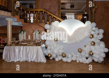 Elegante arredamento per ricevimenti nuziali con arco di mongolfiera e tavolo Sweet. Foto Stock