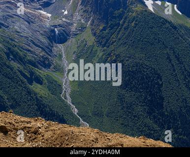 Vista del fiume che scorre fuori da un ghiacciaio di montagna, scenario delle montagne Dombay, Karachay-Cherkessia Repubblica di Russia Foto Stock