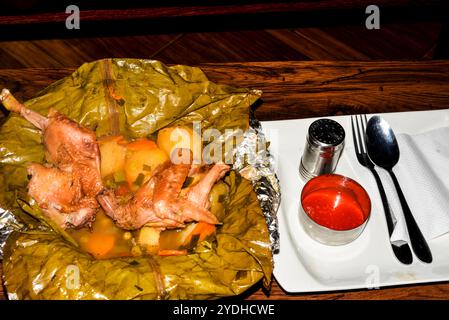 Pasto con luwombo di pollo. Il Luwombo è una cucina tradizionale ugandese popolare nell'Uganda centrale. Viene preparato bollendo carne, pollo o pesce avvolti Foto Stock