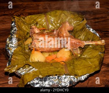 Pasto con luwombo di pollo. Il Luwombo è una cucina tradizionale ugandese popolare nell'Uganda centrale. Viene preparato bollendo carne, pollo o pesce avvolti Foto Stock