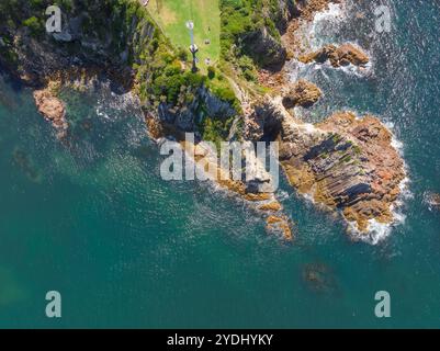 Vista aerea di un aspro promontorio costiero con geologia vulcanica a Eden, sulla costa meridionale del nuovo Galles del Sud, Australia. Foto Stock