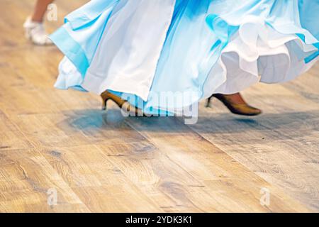 la ragazza con un abito da ballo azzurro balla sulla pista da ballo durante il torneo. Sala da ballo Foto Stock