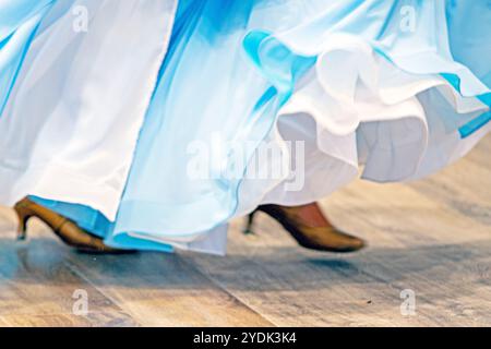 la ragazza con un abito da ballo azzurro balla sulla pista da ballo durante il torneo. Sala da ballo Foto Stock