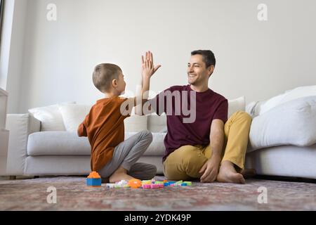 Felice padre e figlio fiero che fanno cinque alti di successo Foto Stock