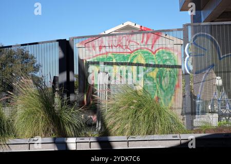 Le vecchie capanne dei tram viste dalla stazione di Newtown, gli edifici industriali in disuso le pareti in mattoni, il tetto delle seghe e i graffiti Foto Stock