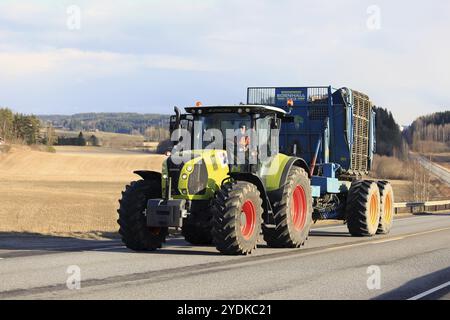 SALO, FINLANDIA, 13 APRILE 2017: Un agricoltore guida il moderno trattore agricolo Claas Arion 640 e la trebbiatrice di barbabietole Edenhall 733 lungo la strada in una splendida serata di Foto Stock