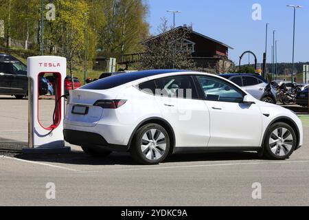 Batteria di ricarica per auto elettriche Tesla Model Y AWD bianca presso la stazione Supercharger Tesla a Salo, Finlandia. 11 maggio 2024 Foto Stock