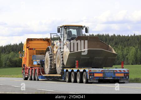 JOKIOINEN, FINLANDIA, 16 GIUGNO 2017: Il rimorchio a collo d'oca personalizzato Scania G580 del gruppo PHP trasporta la pala gommata Cat 980H lungo l'autostrada a. Foto Stock