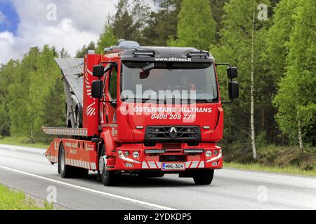 Rimorchio a pianale Renault, veicolo di recupero di Ostermans Alltrans Ab Oy che trasporta auto danneggiata lungo l'autostrada in giornata nuvolosa. Raasepori, Finlandia. 24 maggio, Foto Stock