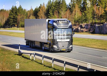 Furgone nero DAF XF Roovert dall'Olanda che trasporta un semirimorchio FRC in autostrada in una soleggiata mattina di primavera. Salo, Finlandia. 30 aprile 2021 Foto Stock