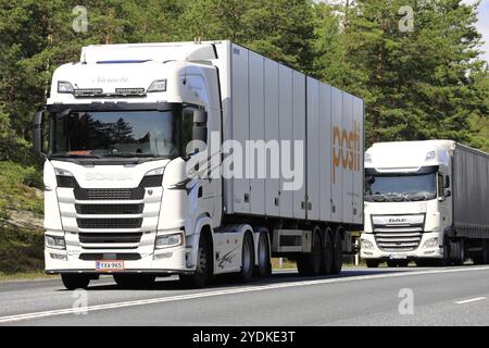 I veicoli con semirimorchio White Scania S500 e DAF XF trasportano merci sull'autostrada 3 direzione sud in estate. Ikaalinen, Finlandia. 12 agosto 2021 Foto Stock