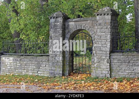 Vecchio muro di pietra e cancello di ferro in un giorno d'autunno. Helsinki, Finlandia, Europa Foto Stock