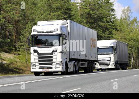 I veicoli con semirimorchio White Scania S500 e DAF XF trasportano merci sull'autostrada 3 direzione sud in estate. Ikaalinen, Finlandia. 12 agosto 2021 Foto Stock