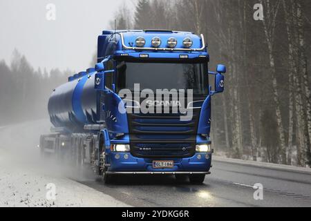 TENHOLA, FINLANDIA, 4 FEBBRAIO 2017: Il carro armato blu Scania R580 percorre la strada bagnata in una giornata nebbiosa in inverno per prelevare un carico Foto Stock