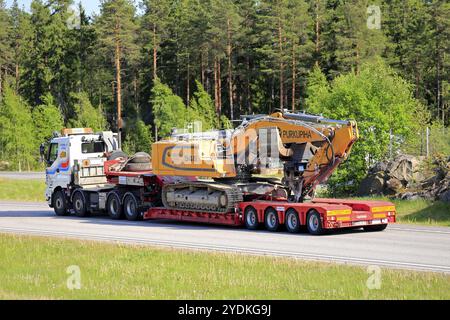 Sisu 18E630 bianco camion di O.. Rinne Oy trasporta grandi escavatori cingolati su rimorchio in autostrada in estate a Paimio, Finlandia, 1° giugno 2018, Europa Foto Stock