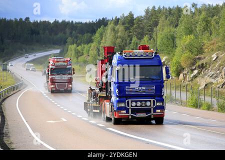 Orivesi, Finlandia, 27 agosto 2018: Due semi-camion trasportano macchinari pesanti su strada bagnata nella Finlandia centrale in una giornata piovosa di fine estate, in Europa Foto Stock