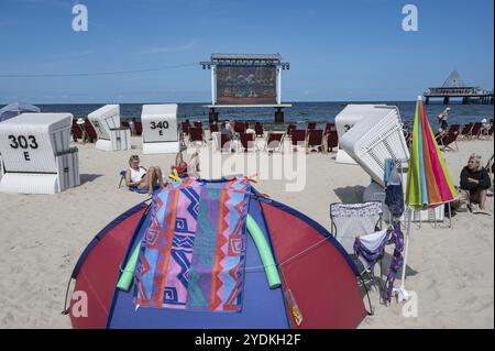 25.07.2024, Heringsdorf, Usedom, Meclemburgo-Pomerania occidentale, Germania, Europa, i turisti si siedono sulla spiaggia nel Kaiserbad Heringsdorf e guardano Foto Stock