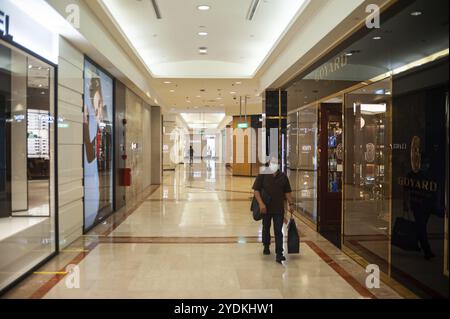 02.04.2020, Singapore, Repubblica di Singapore, Asia, Un uomo passa davanti ai negozi del centro commerciale Takashimaya indossando una maschera per proteggersi da me Foto Stock