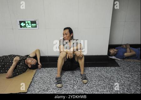 03.08.2012, Chongqing, Cina, Asia, tre uomini che riposano in una metropolitana con aria condizionata, Asia Foto Stock