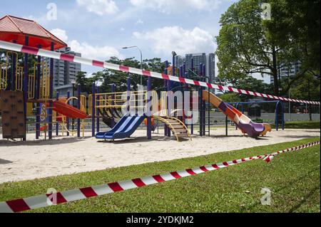 10.04.2020, Singapore, Repubblica di Singapore, Asia, Un parco giochi nel distretto di Ang Mo Kio è stato circondato da barriere rosse e bianche. Aggiungi Foto Stock