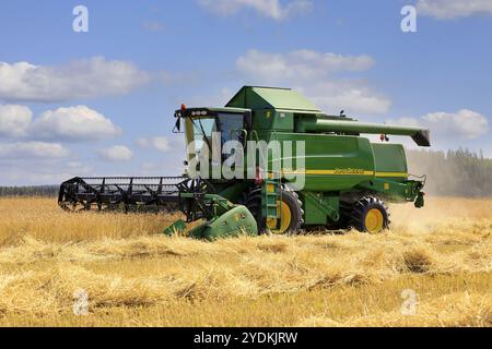 La mietitrebbiatrice John Deere 9560i WTS raccoglie il grano in una splendida giornata di luglio. La stagione della raccolta inizia all'inizio del 2021. Salo, Finlandia. 25 luglio, 21 Foto Stock