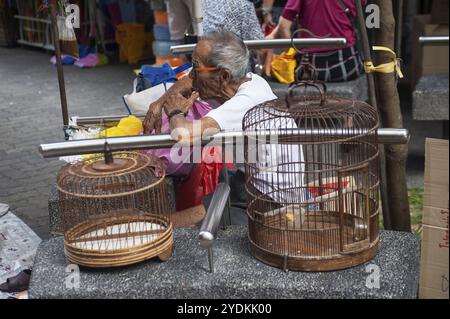 10/02/2018, Singapore, Repubblica di Singapore, Asia, Un uomo vende due gabbie di uccelli usate in un piccolo mercato delle pulci vicino al Tempio reliquico del dente del Buddha a Singa Foto Stock