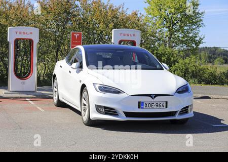 PAIMIO, FINLANDIA, 3 GIUGNO 2017: La berlina di lusso Tesla Model S bianca con nuovo design all'esterno del veicolo viene caricata presso la stazione Supercharger di Tesla Foto Stock