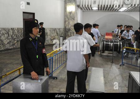 09.08.2012, Pyongyang, Corea del Nord, Asia, pendolari nordcoreani mostrano i loro biglietti a un dipendente in uniforme mentre entrano in una stazione della metropolitana a Py Foto Stock