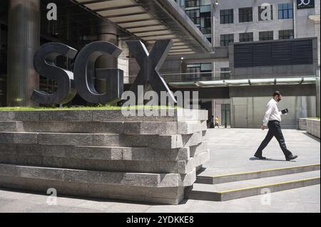 05.05.2020, Singapore, Repubblica di Singapore, Asia, Un uomo oltrepassa il logo di fronte all'edificio SGX Centre, la borsa valori dell'azienda Foto Stock
