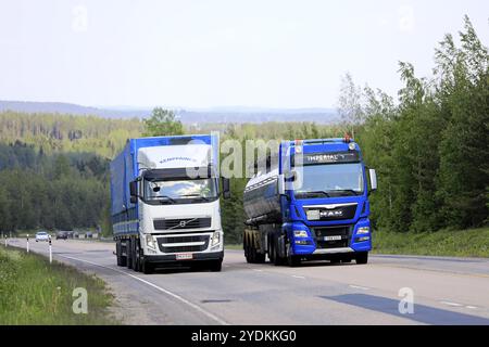 Jamsa, Finlandia. 6 giugno 2019. La semi-autocisterna Blue MAN passa davanti a un altro camion che procede in salita sull'autostrada. I carrelli con carico pesante possono essere molto più lenti in salita Foto Stock