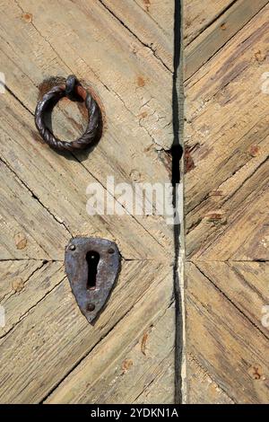 Bottone e buco della porta in ferro battuto sulla vecchia porta in legno della chiesa di Sauvo, Sauvo, Finlandia, Europa Foto Stock