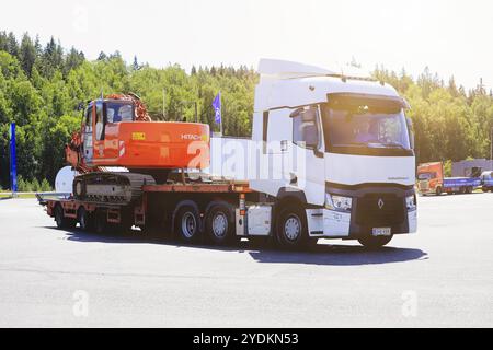 White Renault Trucks T trasporta l'escavatore cingolato Hitachi Zaxis 225 US su rimorchio con pianale ribaltabile, vista laterale. Forte, Finlandia. 31 luglio 2020 Foto Stock