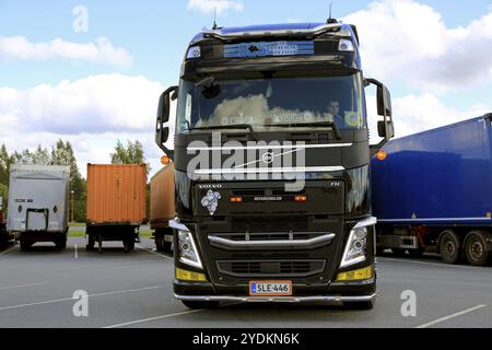 ALAHARMA, FINLANDIA, 12 AGOSTO 2016: La Volvo FH nera di SCS Truck driver distacca un rimorchio di carico in un deposito di sosta per camion Foto Stock