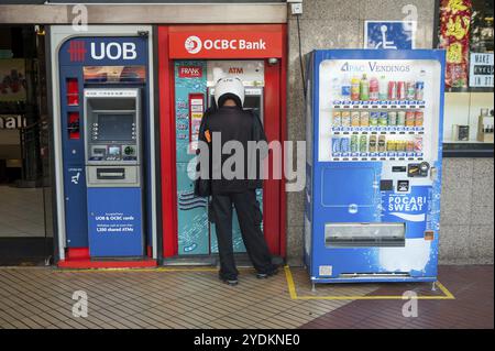 22/02/2018, Singapore, Repubblica di Singapore, Asia, Un uomo ritira denaro da un bancomat nel centro di Singapore, Asia Foto Stock