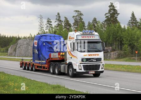 PAIMIO, FINLANDIA, 9 GIUGNO 2017: Veicolo Volvo FH16 bianco di Myntt Oy trasporta oggetti industriali ABB su rimorchio come carico largo nel sud della Finlandia Foto Stock