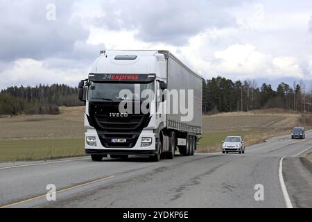 SALO, FINLANDIA, 13 APRILE 2017: Il mezzo Iveco Stralis Hi-Way bianco trasporta un rimorchio con teloni scorrevoli nel traffico in un giorno torbido di primavera Foto Stock