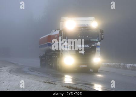 Salo, Finlandia, 28 dicembre 2018: Fari luminosi del carro armato Scania R520 di nuova generazione da MM Tolvanen attraverso una fitta nebbia sull'autostrada invernale, Euro Foto Stock