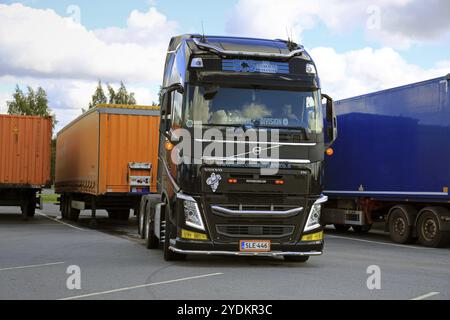 ALAHARMA, FINLANDIA, 12 AGOSTO 2016: Il conducente di veicoli Volvo FH di colore nero scollega un rimorchio di carico in un deposito di sosta per camion Foto Stock