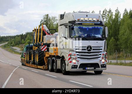 ORIVESI, FINLANDIA, 27 AGOSTO 2018: Semirimorchio Mercedes-Benz Actros di Hansedrive trasporta macchine forestali su autostrada in Finlandia il giorno coperto Foto Stock