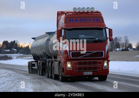 SALO, FINLANDIA, 15 GENNAIO 2017: Il carro armato Volvo FH rosso per il trasporto di merci sfuse consegna un carico lungo l'autostrada al crepuscolo in inverno Foto Stock