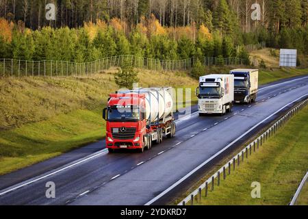 Tre autocarri merci che trasportano carichi lungo la superstrada in un giorno d'autunno, vista elevata. Salo, Finlandia. 29 ottobre 2020 Foto Stock