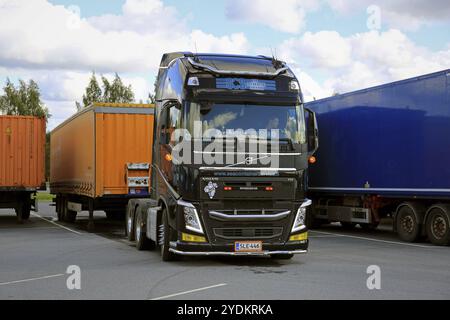 ALAHARMA, FINLANDIA, 12 AGOSTO 2016: Il conducente di veicoli Volvo FH di colore nero scollega un rimorchio di carico in un deposito di sosta per camion Foto Stock