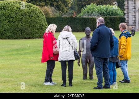 Persone che guardano una delle figure del Time Horizon di Antony Gormley alla Houghton Hall di Norfolk. Foto Stock