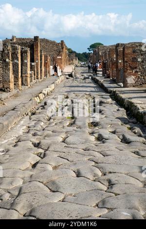 Strada lastricata di pietra che mostra solchi di carri e carri, Parco Archeologico di Pompei, Napoli, Italia. Foto Stock