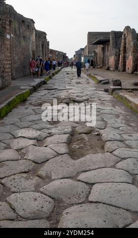 Strada lastricata di pietra che mostra solchi di carri e carri, Parco Archeologico di Pompei, Napoli, Italia. Foto Stock